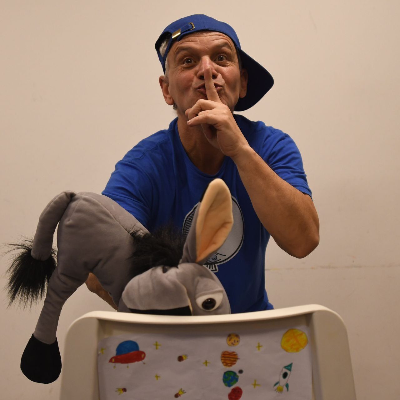 Ein Mann in einem blauen Hemd hält einen ausgestopften Esel