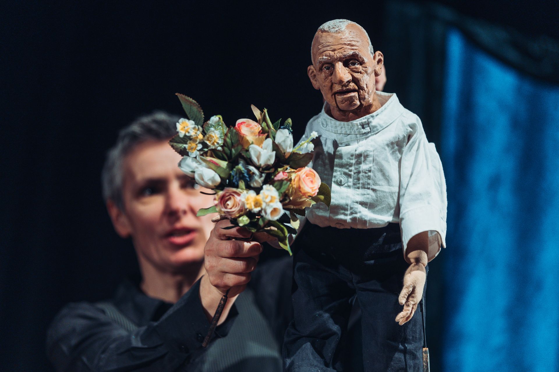 Ein Mann hält eine Puppe mit Blumen in seinen Händen