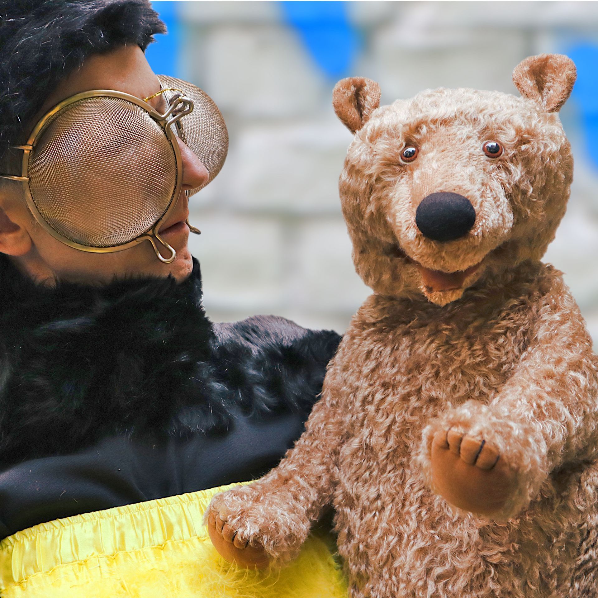 Ein Mann mit Sonnenbrille hält einen Teddybär