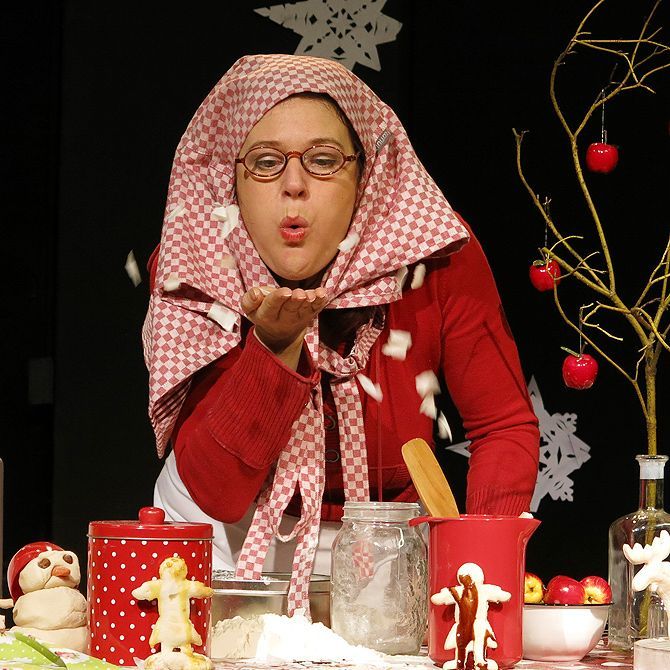 Eine Frau mit einem rot-weiß karierten Schal wirft einen Kuss zu