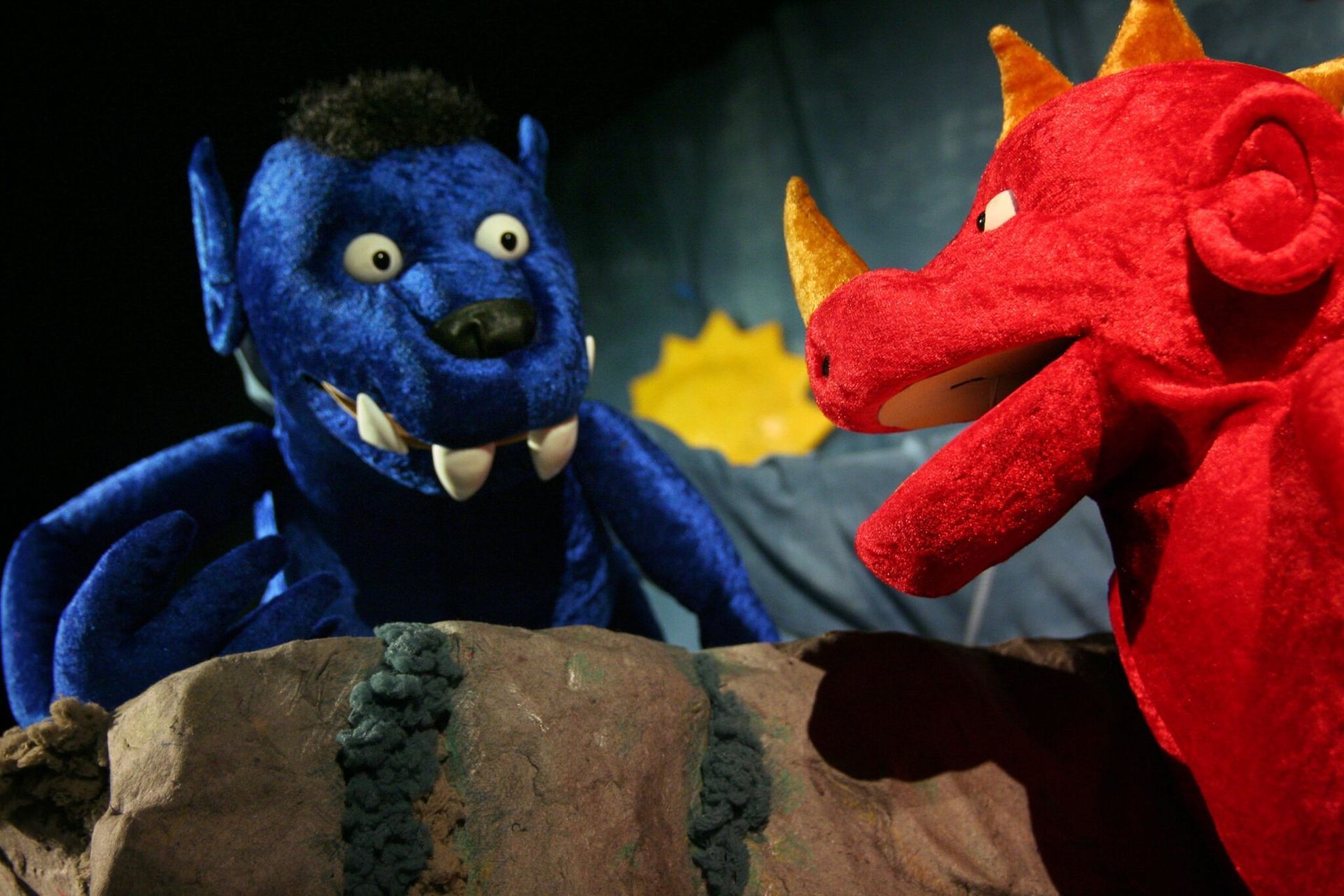 Ein blaues Monster und ein roter Drache stehen nebeneinander
