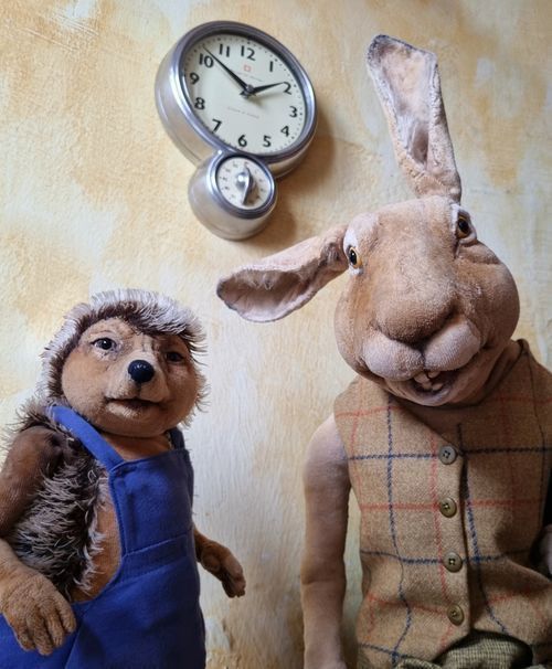 Ein Kaninchen und ein Igel stehen vor einer Uhr