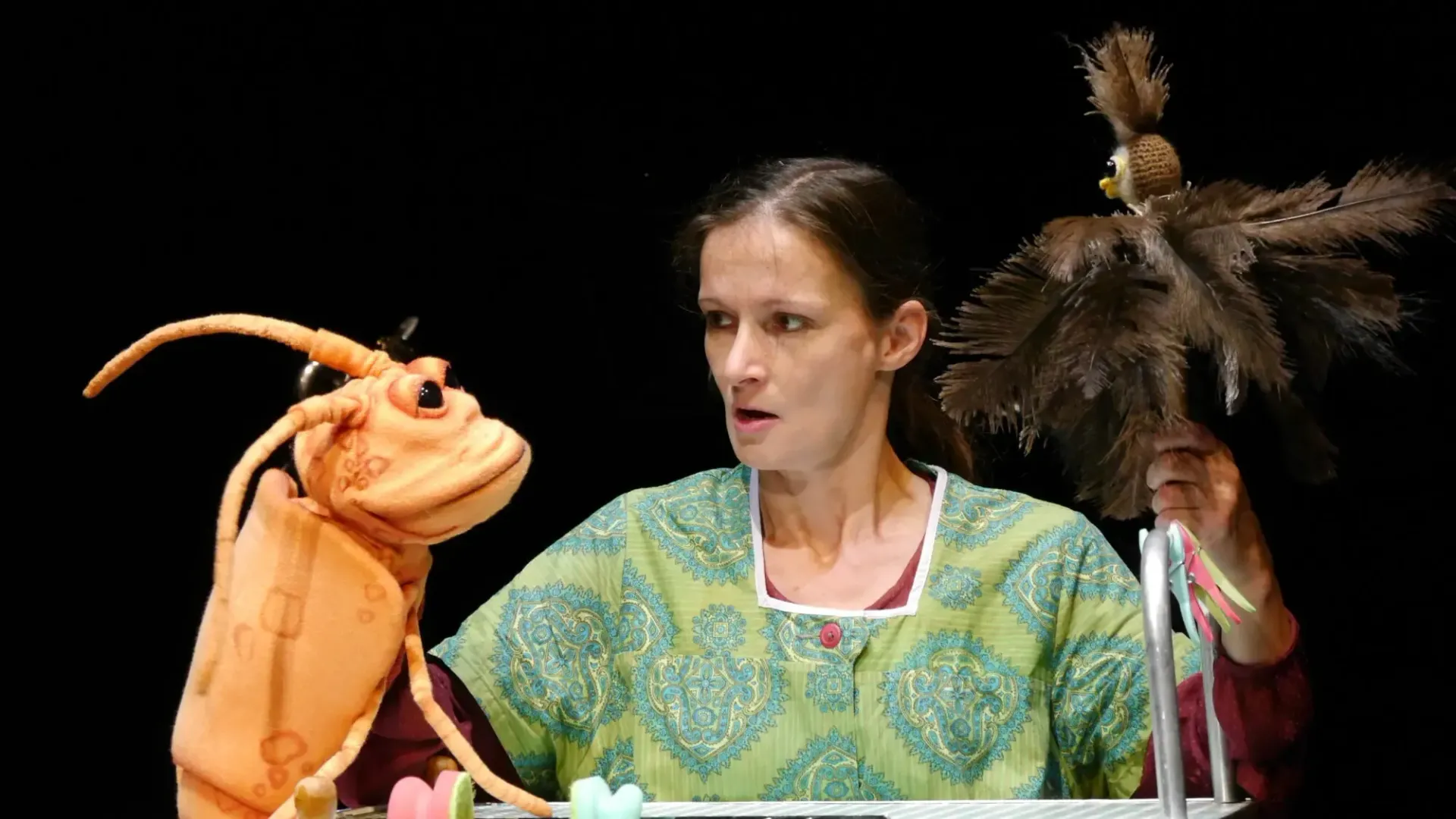 Eine Frau spielt mit einer Kakerlakenpuppe