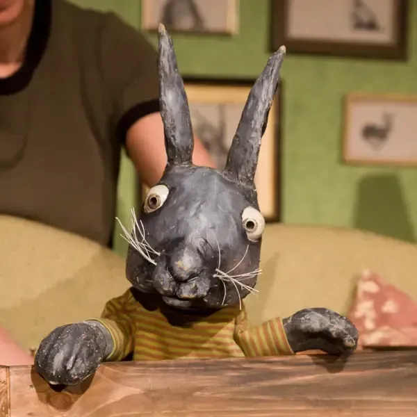 Eine Kaninchenpuppe mit einem gelb-schwarz gestreiften Hemd