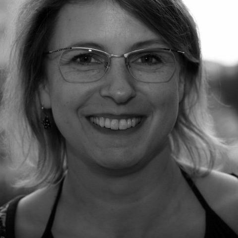 Auf einem Schwarzweißfoto lächelt eine Frau mit Brille.