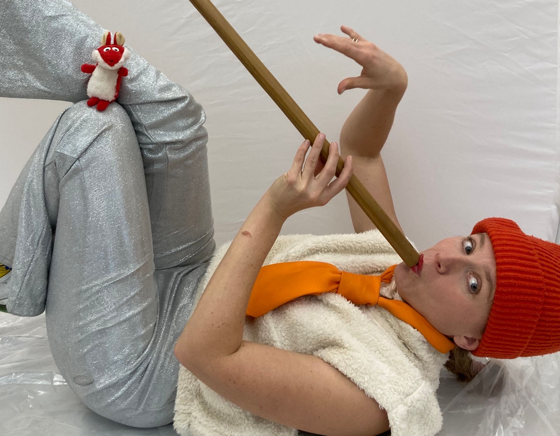 Eine Frau liegt auf dem Boden und spielt mit einem Stock