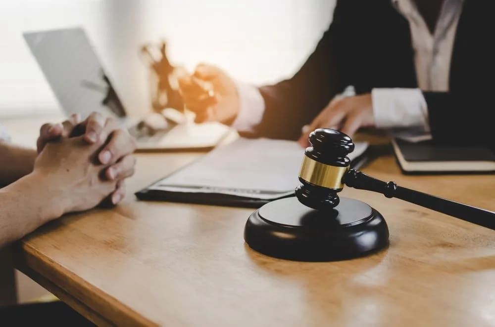A Judge's Gavel Is Sitting On A Wooden Table Next To A Person — Lynda Ross Marriage Celebrant In Alice River, QLD
