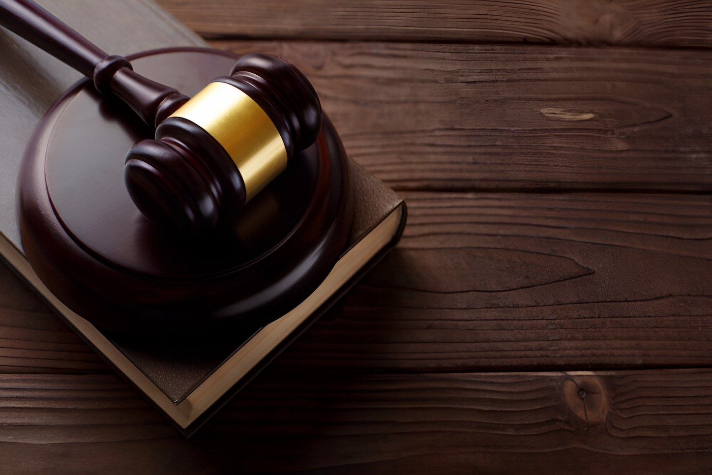 A Wooden Judge's Gavel Is Sitting On Top Of A Book On A Wooden Table — Lynda Ross Marriage Celebrant In Alice River, QLD