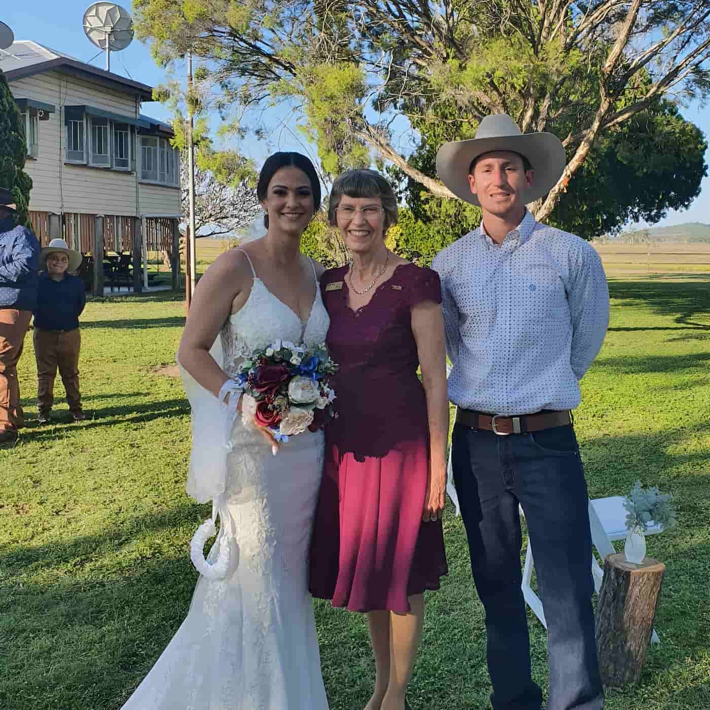 A Bride And Groom Pose For A Photo With Their Marriage Celebrant During Their Wedding Ceremony — Lynda Ross Marriage Celebrant In Alice River, QLD