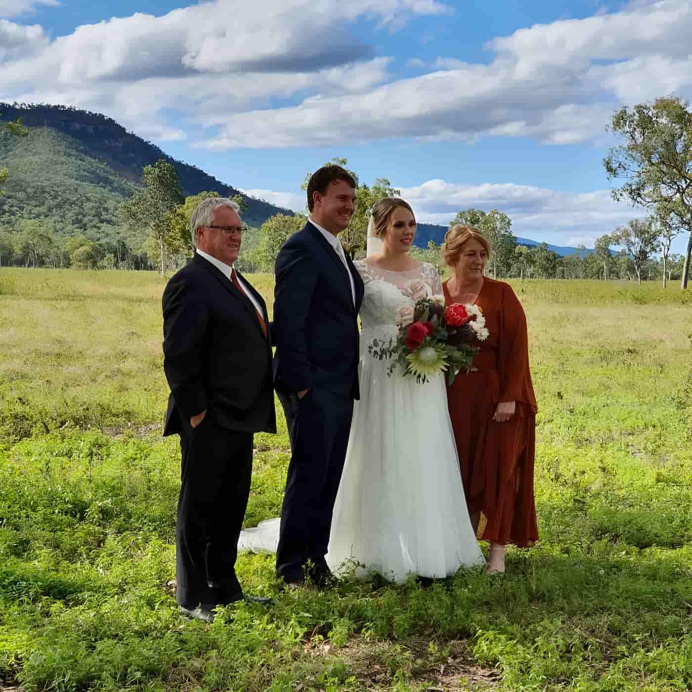 A Bride and Groom with Their Parents Standing In Front of Mountain Scenery — Lynda Ross Marriage Celebrant In Charters Towers, QLD