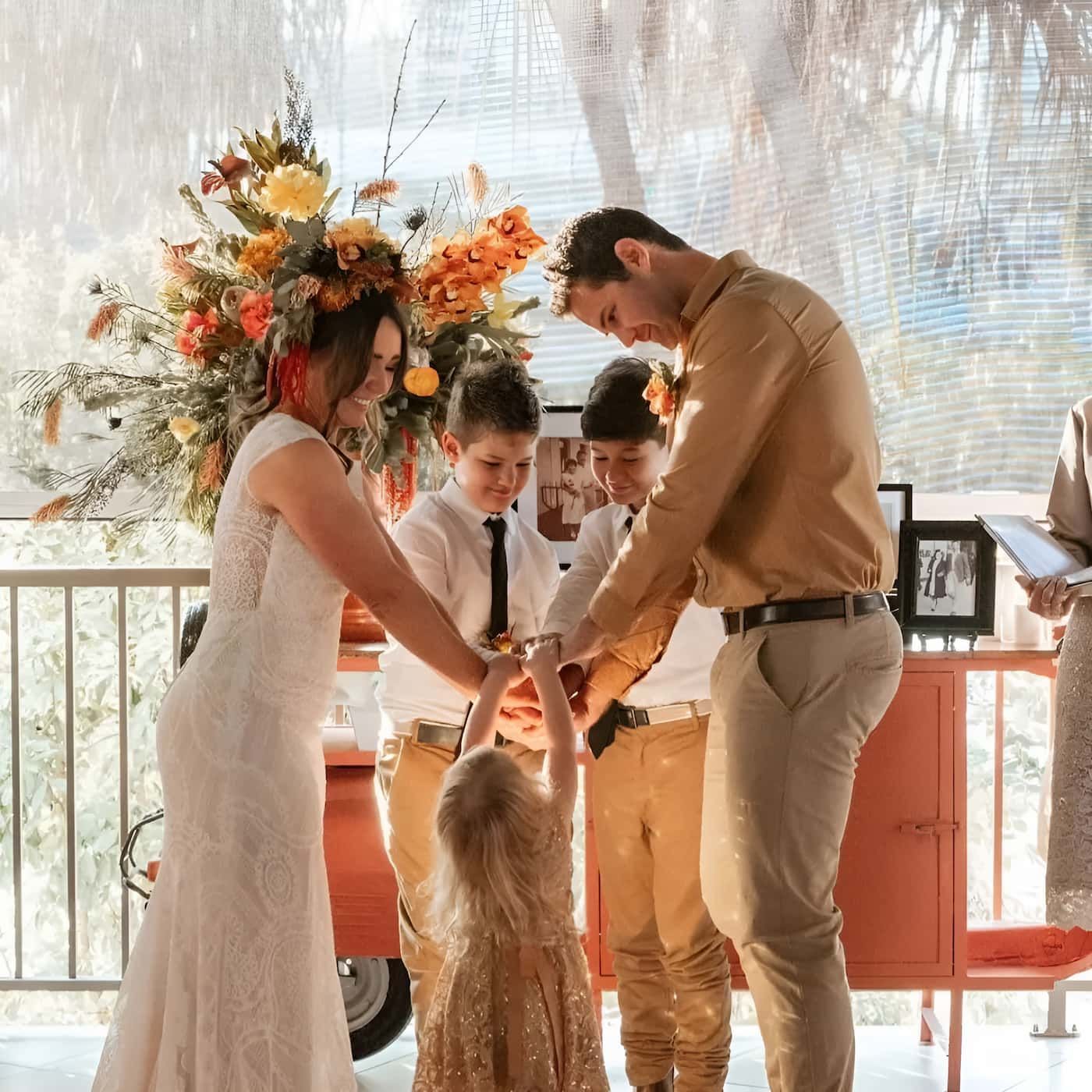 A Bride And Groom Are Holding Hands With Their Children — Lynda Ross Marriage Celebrant In Alice River, QLD