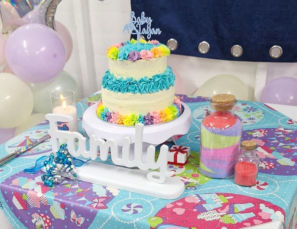 Three Tier Rainbow Celebration Cake With Family Sign In Front — Lynda Ross Marriage Celebrant In Alice River, QLD