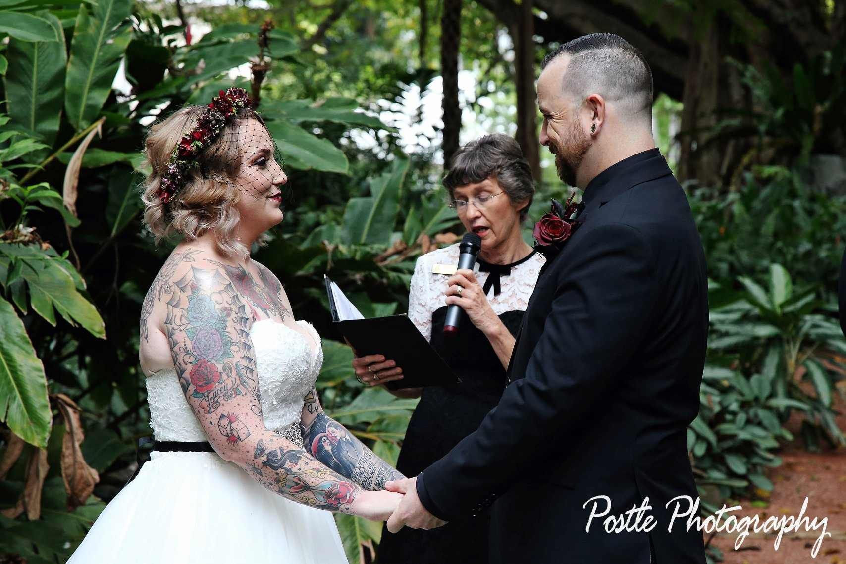 A Bride And Groom Are Holding Hands During Their Wedding Ceremony — Lynda Ross Marriage Celebrant In Alice River, QLD
