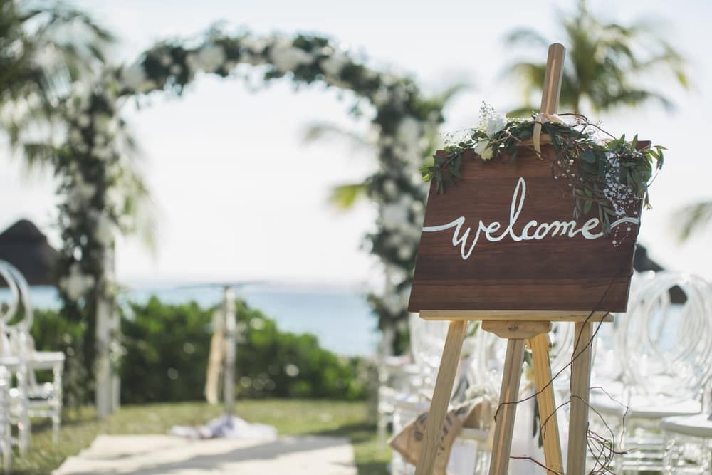 A Wooden Welcome Sign Is On A Wooden Easel At A Wedding — Lynda Ross Marriage Celebrant In North Ward, QLD