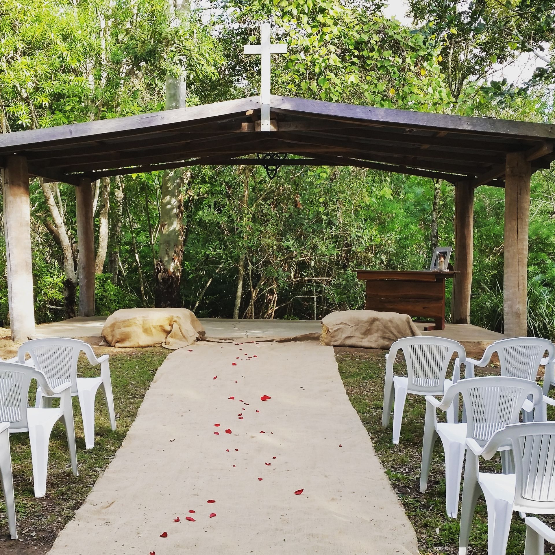 Hervey Range Wedding Outdoor Chapel with chairs & rose petals — Lynda Ross Marriage Celebrant In Hervey Range, QLD