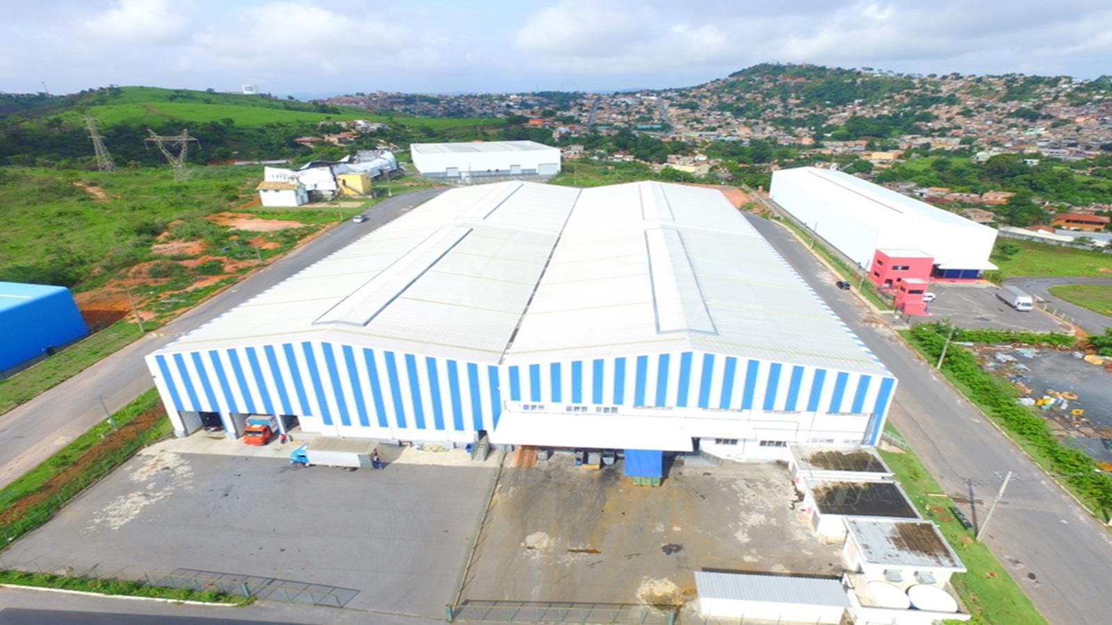 Uma vista aérea de um grande edifício branco em uma área industrial.