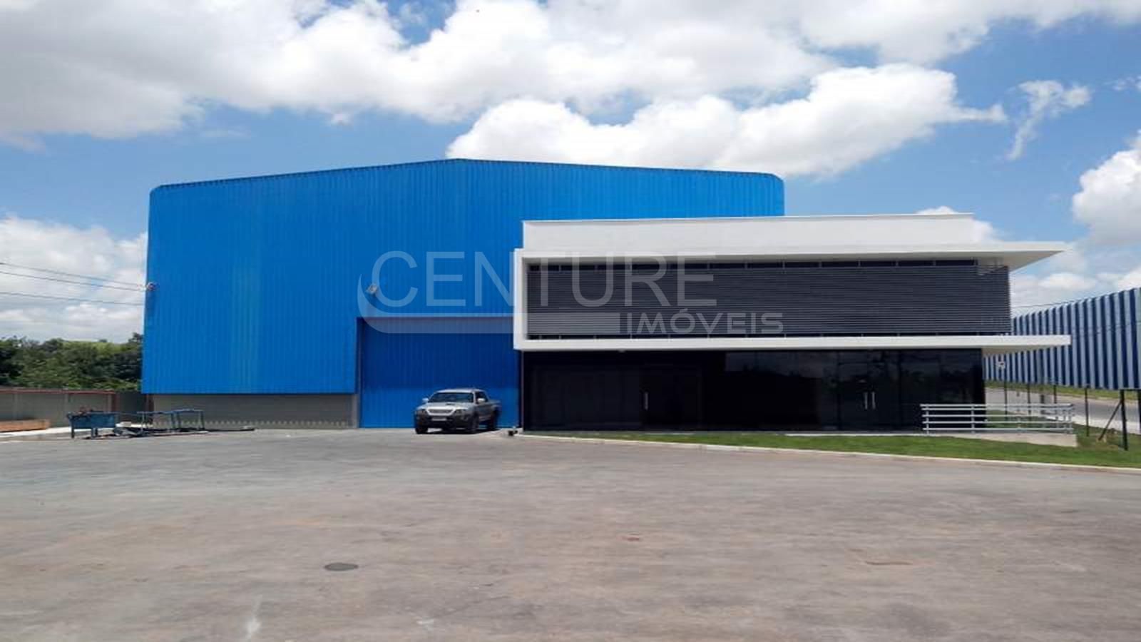 Um grande edifício azul com um carro estacionado na frente.