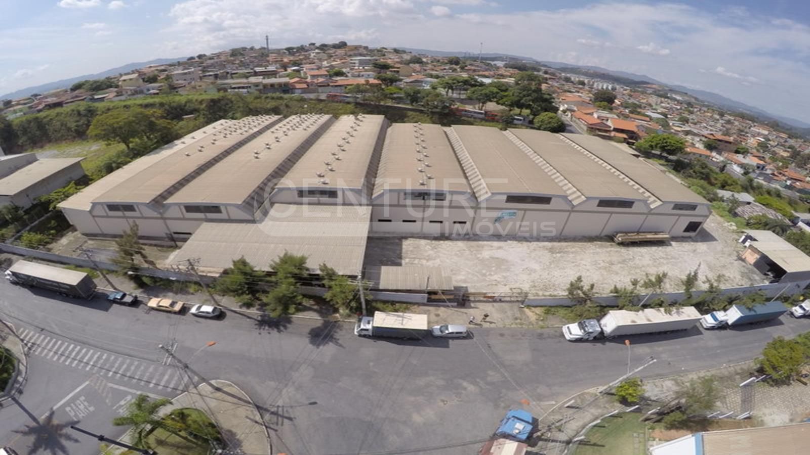 Uma vista aérea de um grande armazém com caminhões estacionados na frente dele.