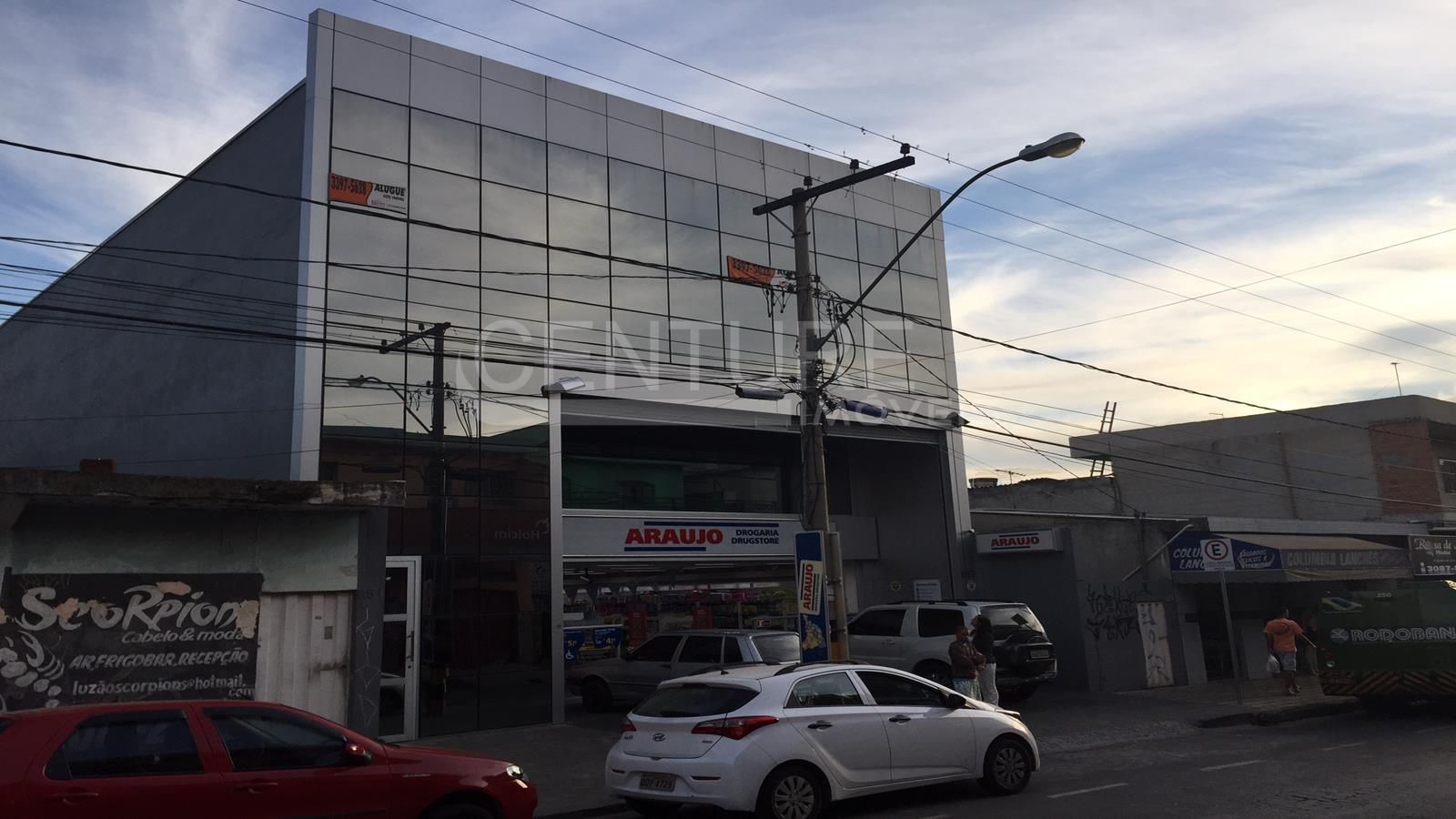 Um carro branco está estacionado em frente a um grande edifício
