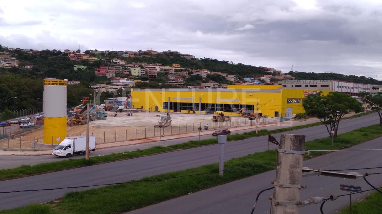 Um prédio amarelo está sendo construído ao lado de uma estrada.
