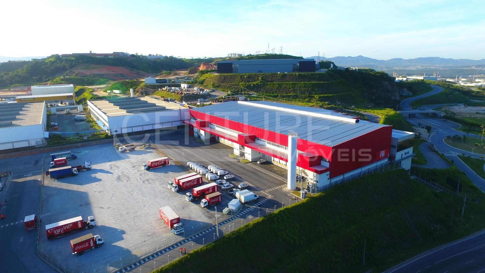 Uma vista aérea de um armazém com caminhões estacionados na frente dele.