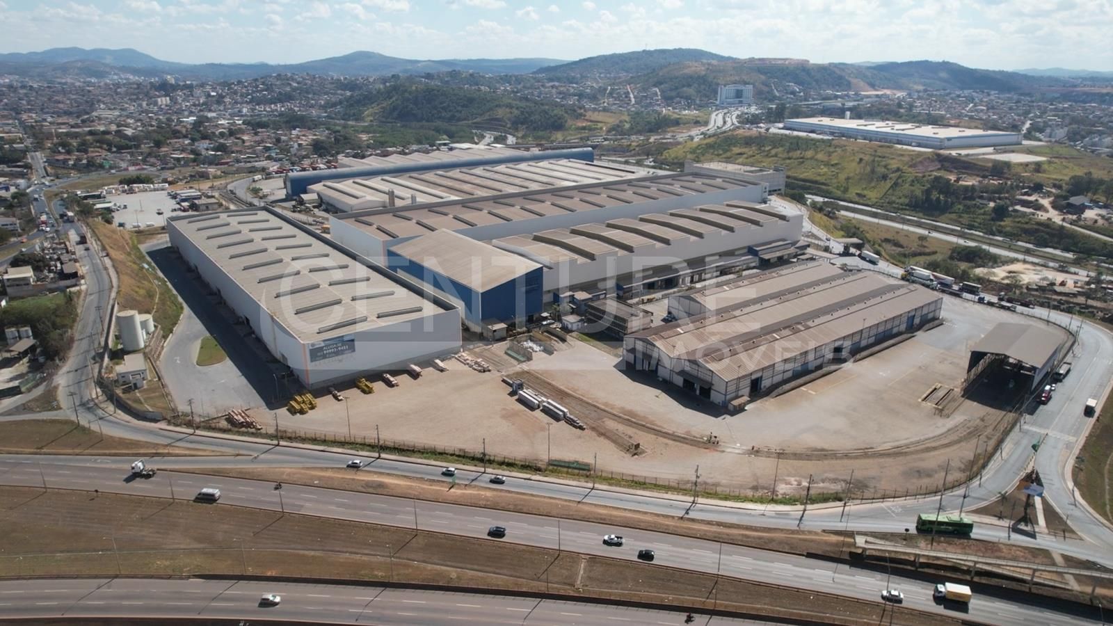 Uma vista aérea de uma grande área industrial com muitos edifícios e uma rodovia.