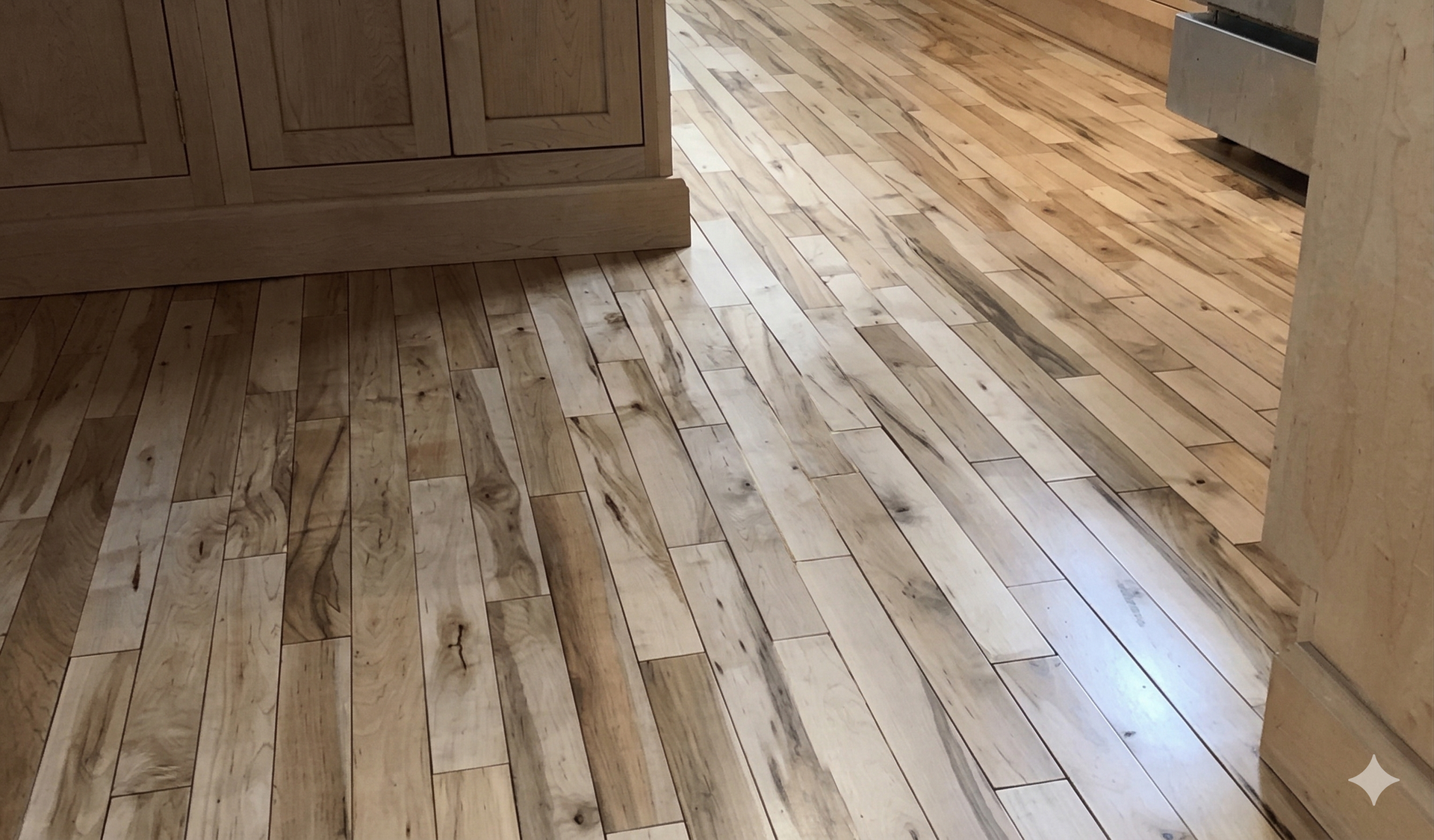 Hardwood floor featuring narrow, light-colored wooden planks with natural grain patterns in a home interior.