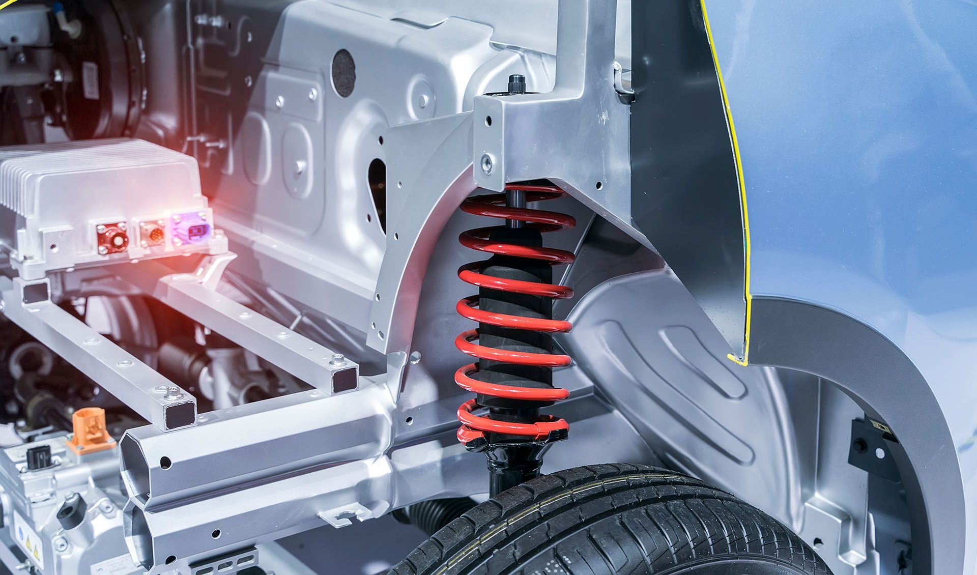 A close up of the underside of an electric car with a shock absorber.