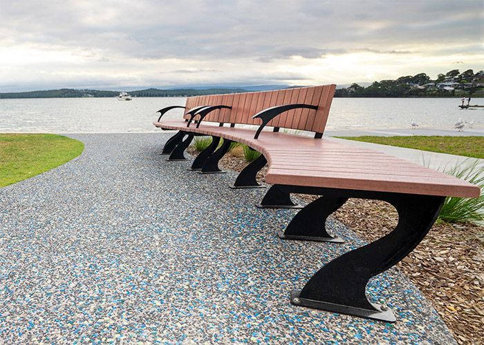 A green and white striped chair is sitting next to a river.