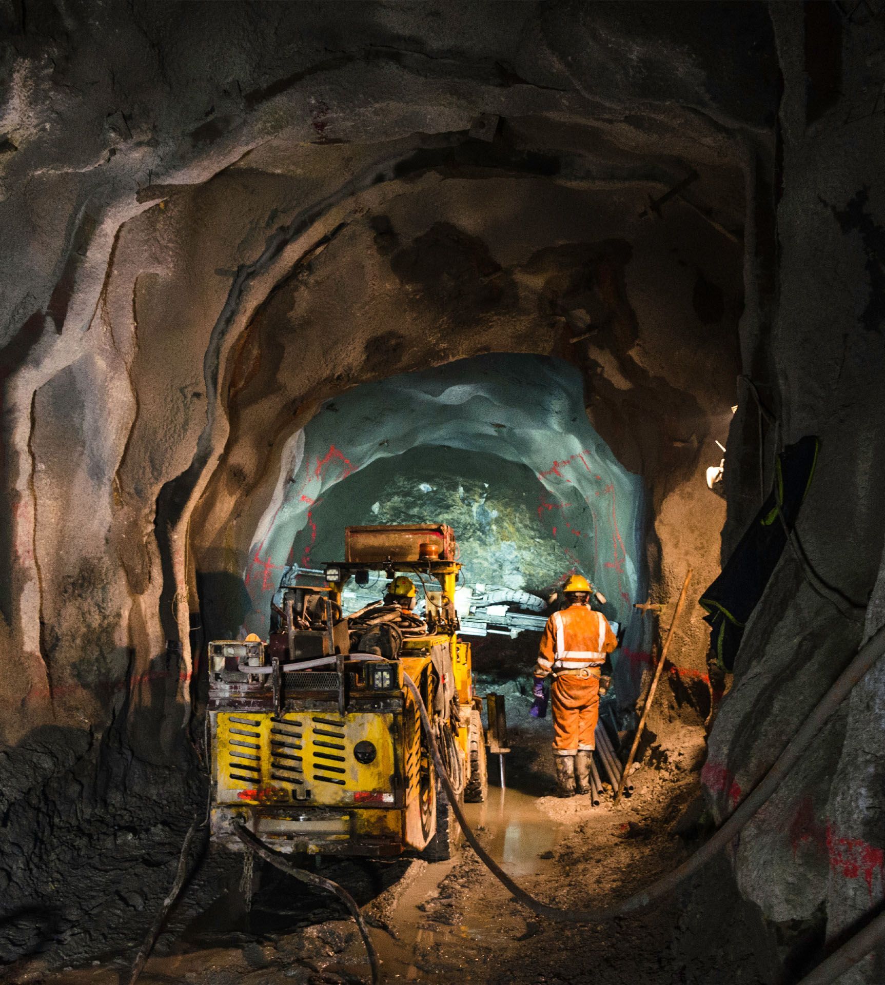 A man is standing in a tunnel looking at a machine