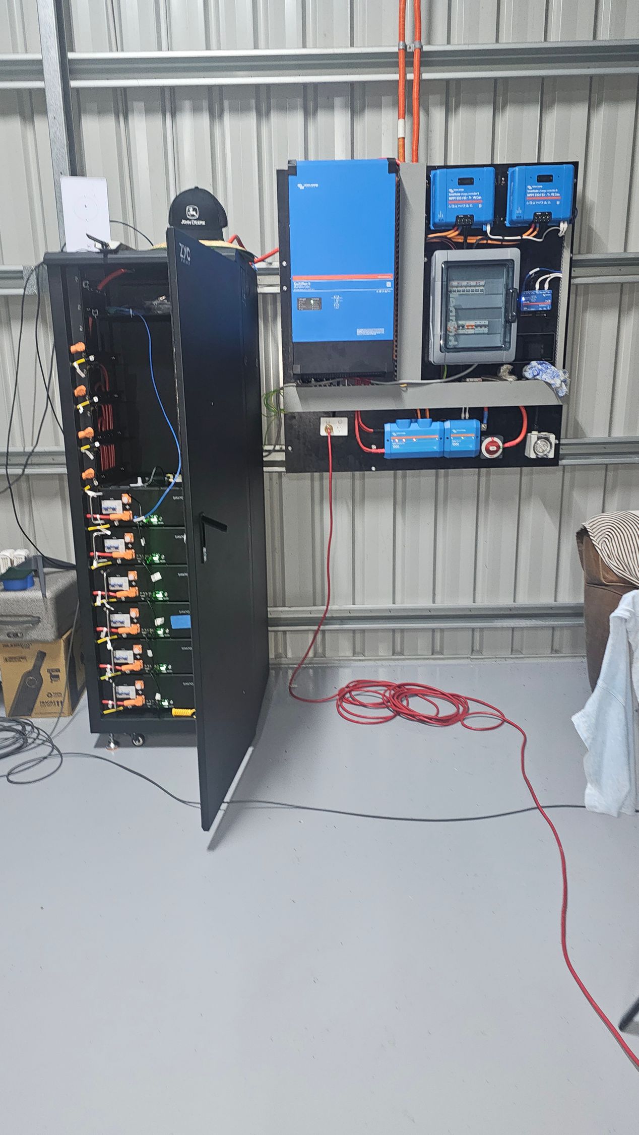 Solar power system inside a metal shed: batteries, inverter, and electrical components on walls — PASMA Electrical In Portsmith, QLD
