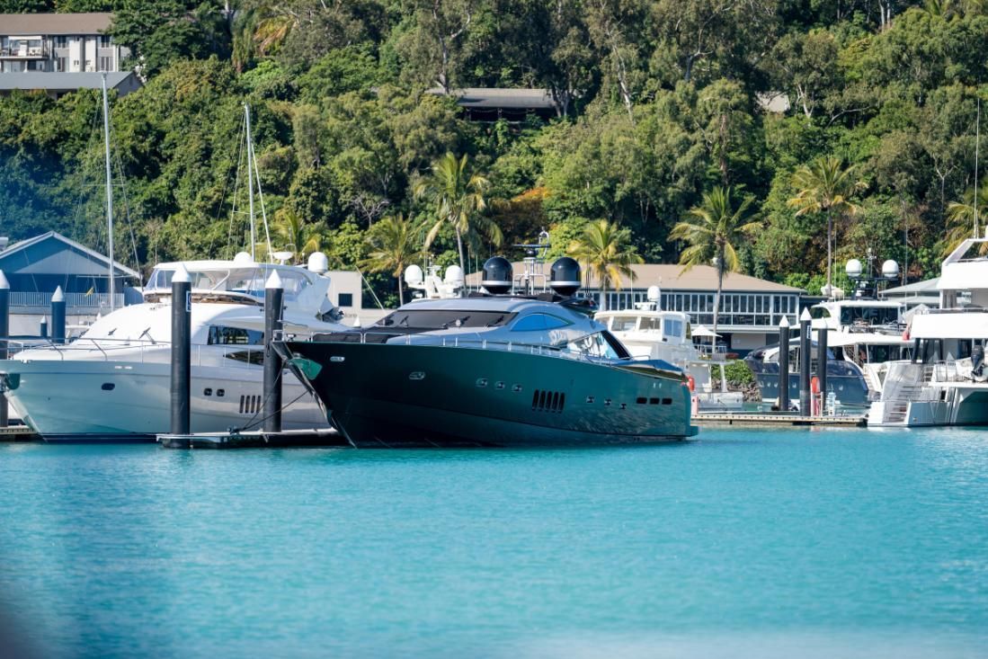 A Group Of Boats Are Docked In A Harbor With Trees In The Background — PASMA Electrical In Mareeba, QLD