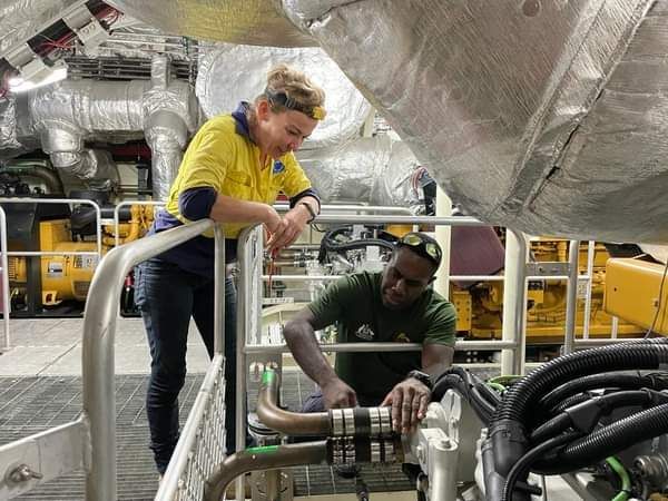 A Man And A Woman Are Working On A Boat Engine — PASMA Electrical In Portsmith, QLD