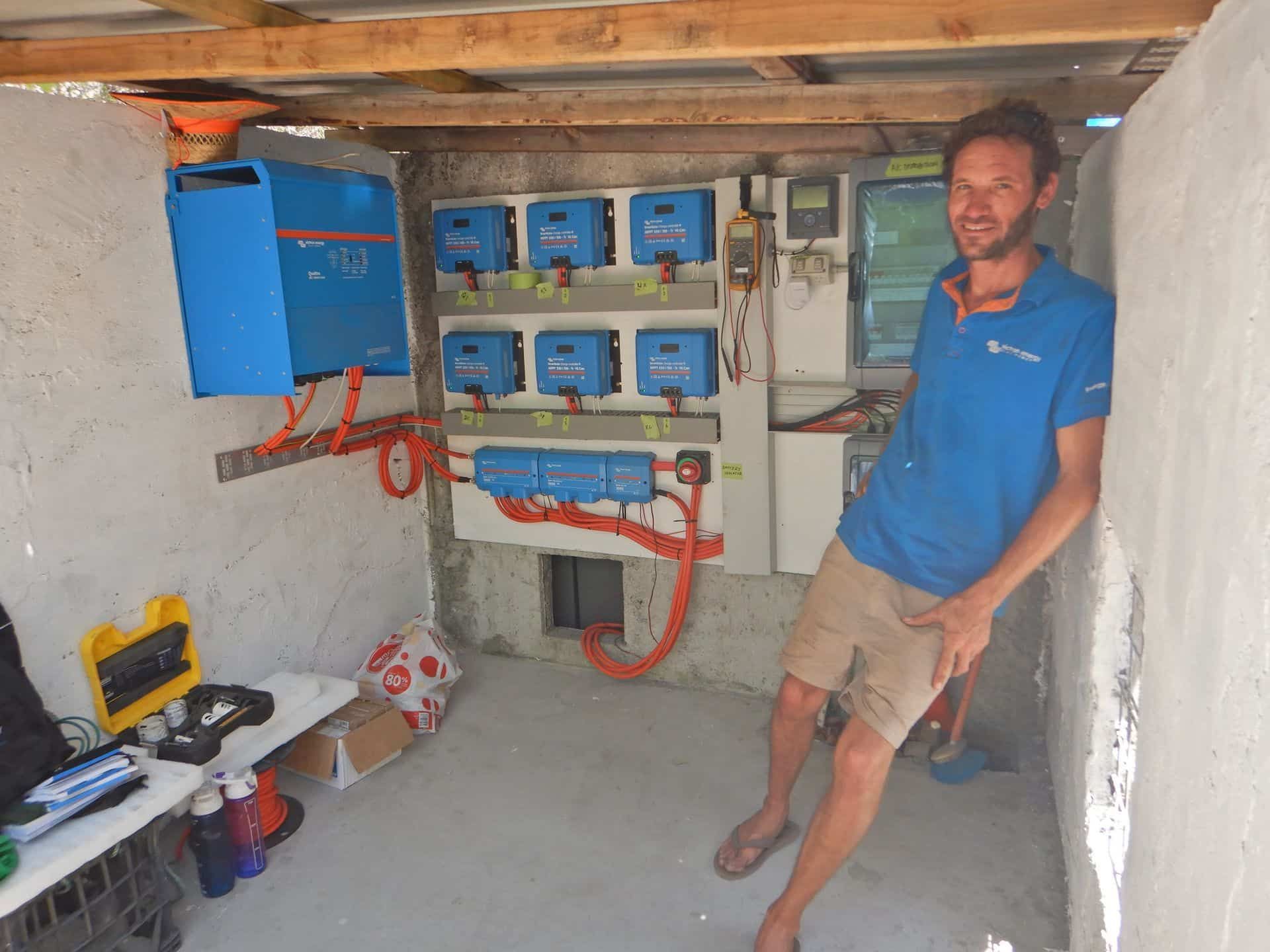 A Man In A Blue Shirt Is Standing In A Room With A Lot Of Blue Boxes On The Wall — PASMA Electrical In Portsmith, QLD