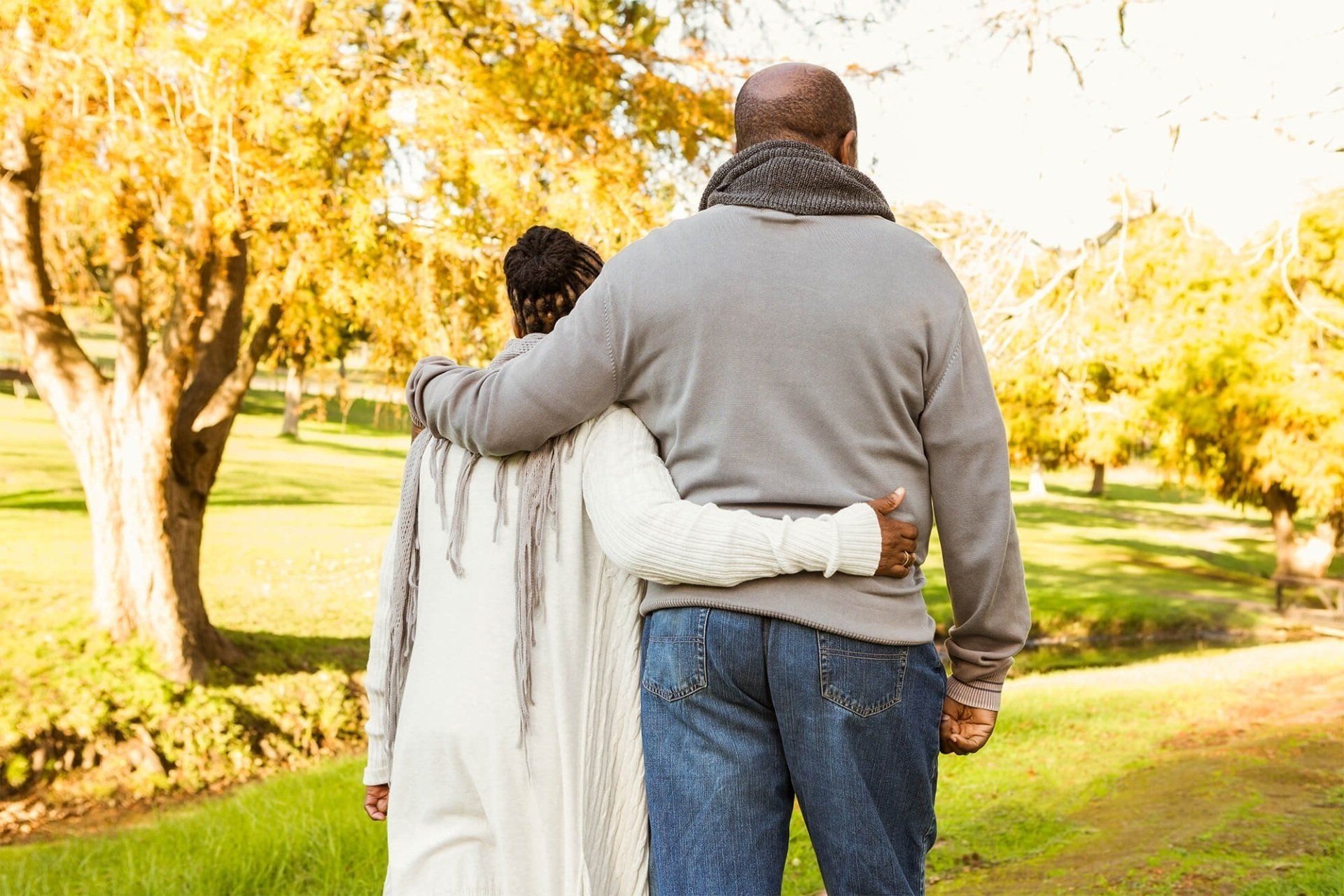a couple walking together with arms over each other