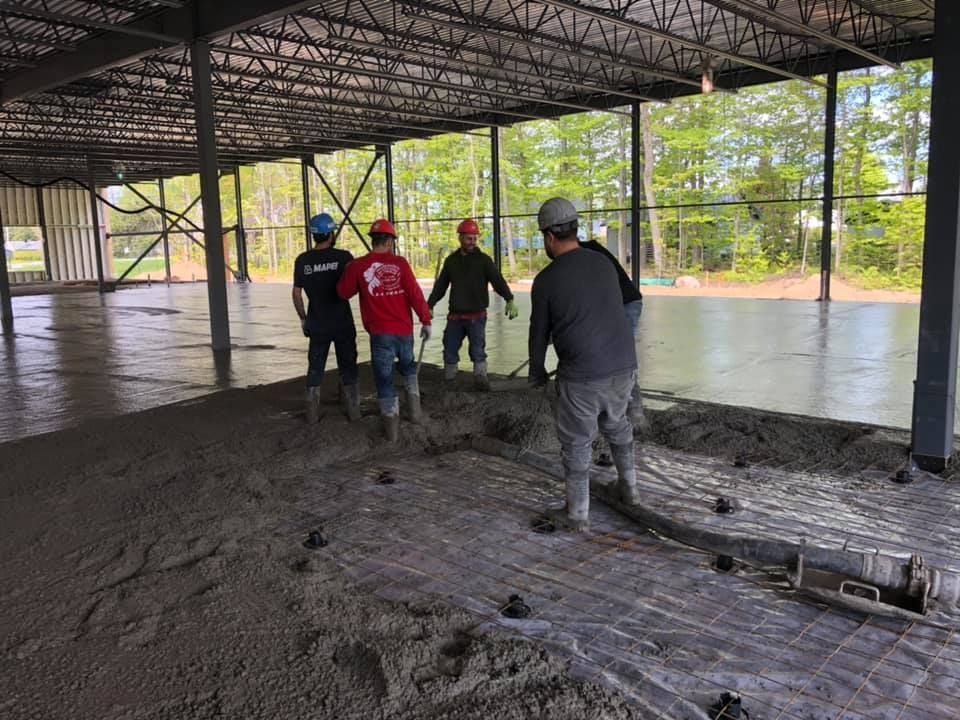 Un groupe d'ouvriers du bâtiment travaillent sur un sol en béton.