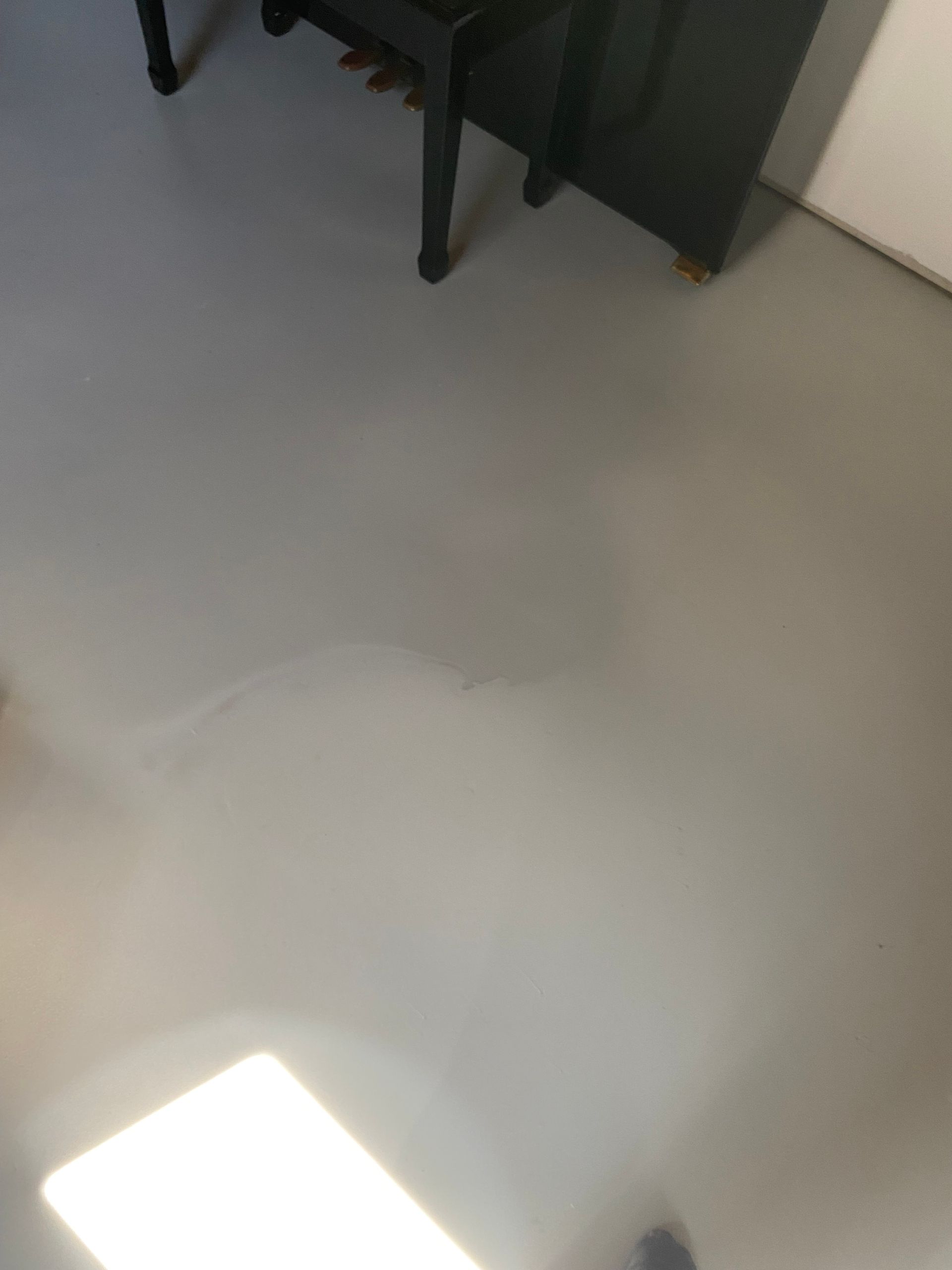 Un piano est posé sur un sol blanc dans une pièce.