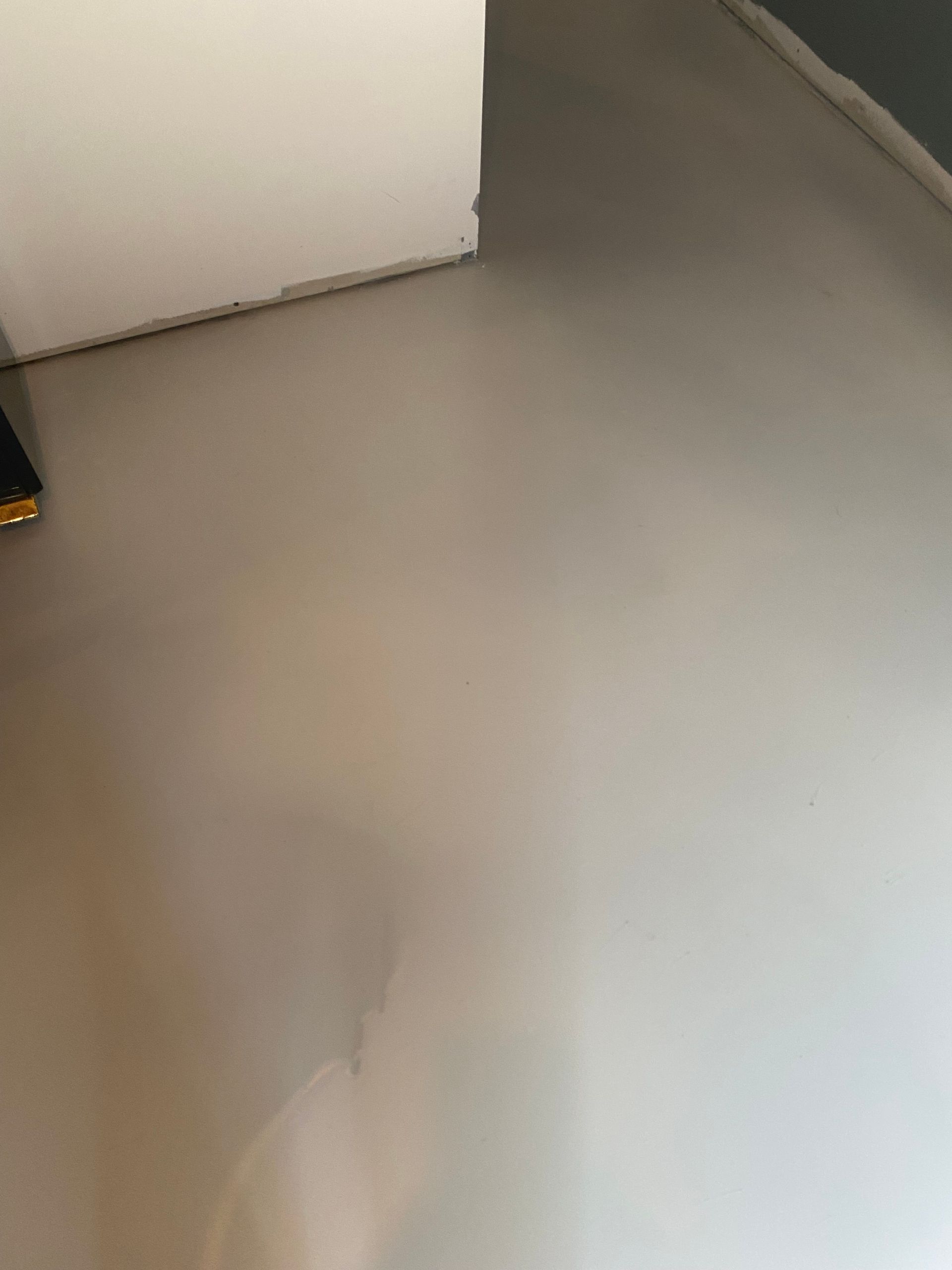 Une personne se tient sur un sol blanc dans une pièce.