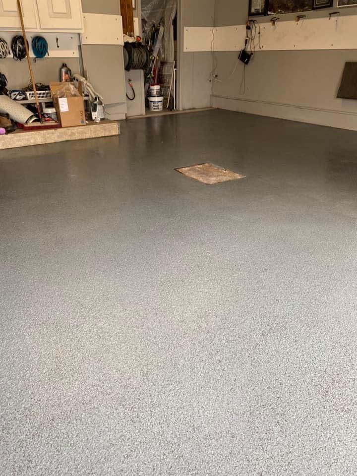 Un garage avec un sol gris et un trou dans le sol.