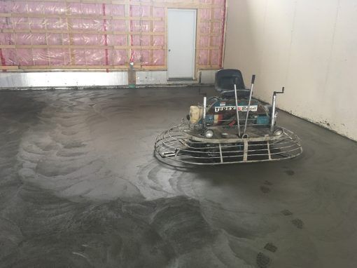 Une machine pose du béton dans une pièce.