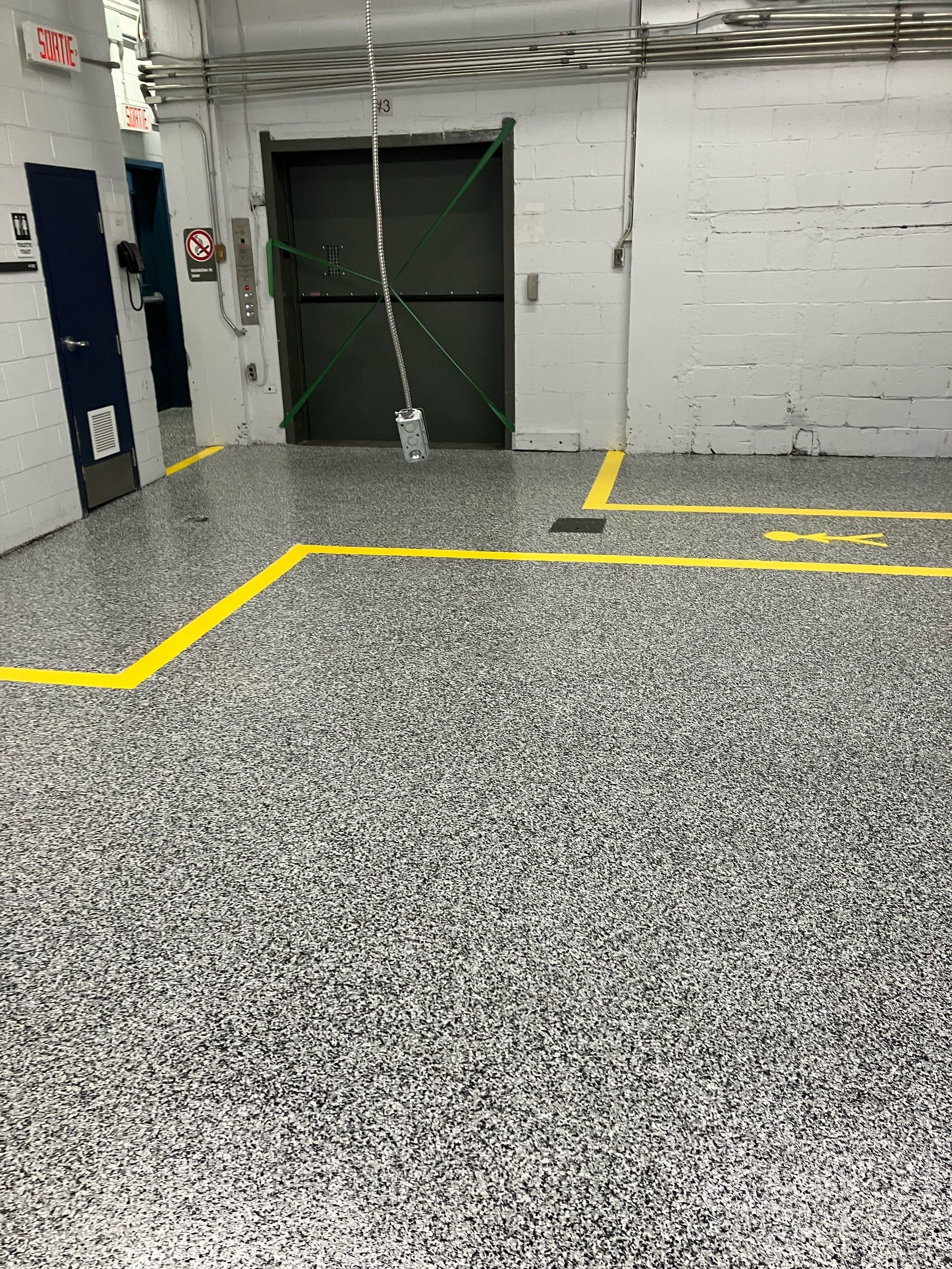 Un garage avec une place handicapée et une ligne jaune au sol.