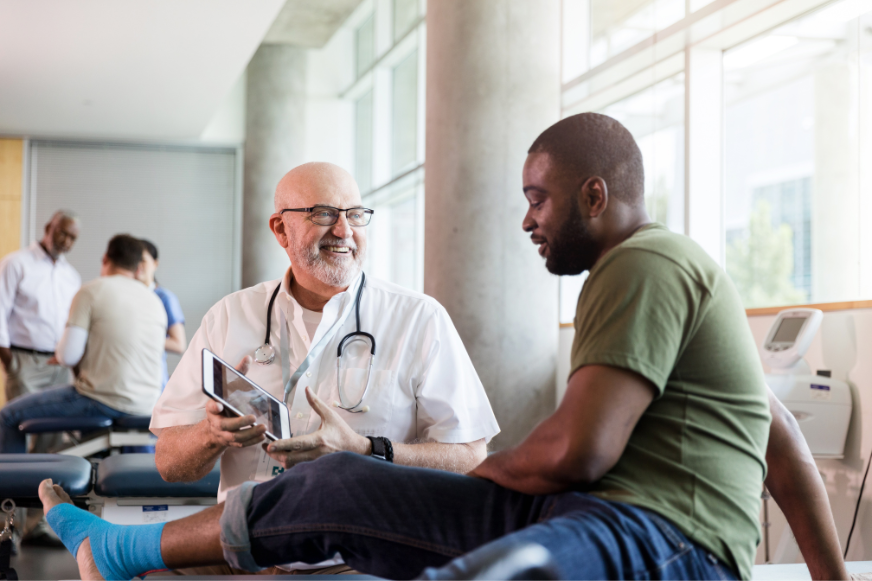 a doctor is examining a patient 's leg in a hospital .