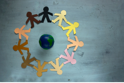 a circle of paper people holding hands around a globe