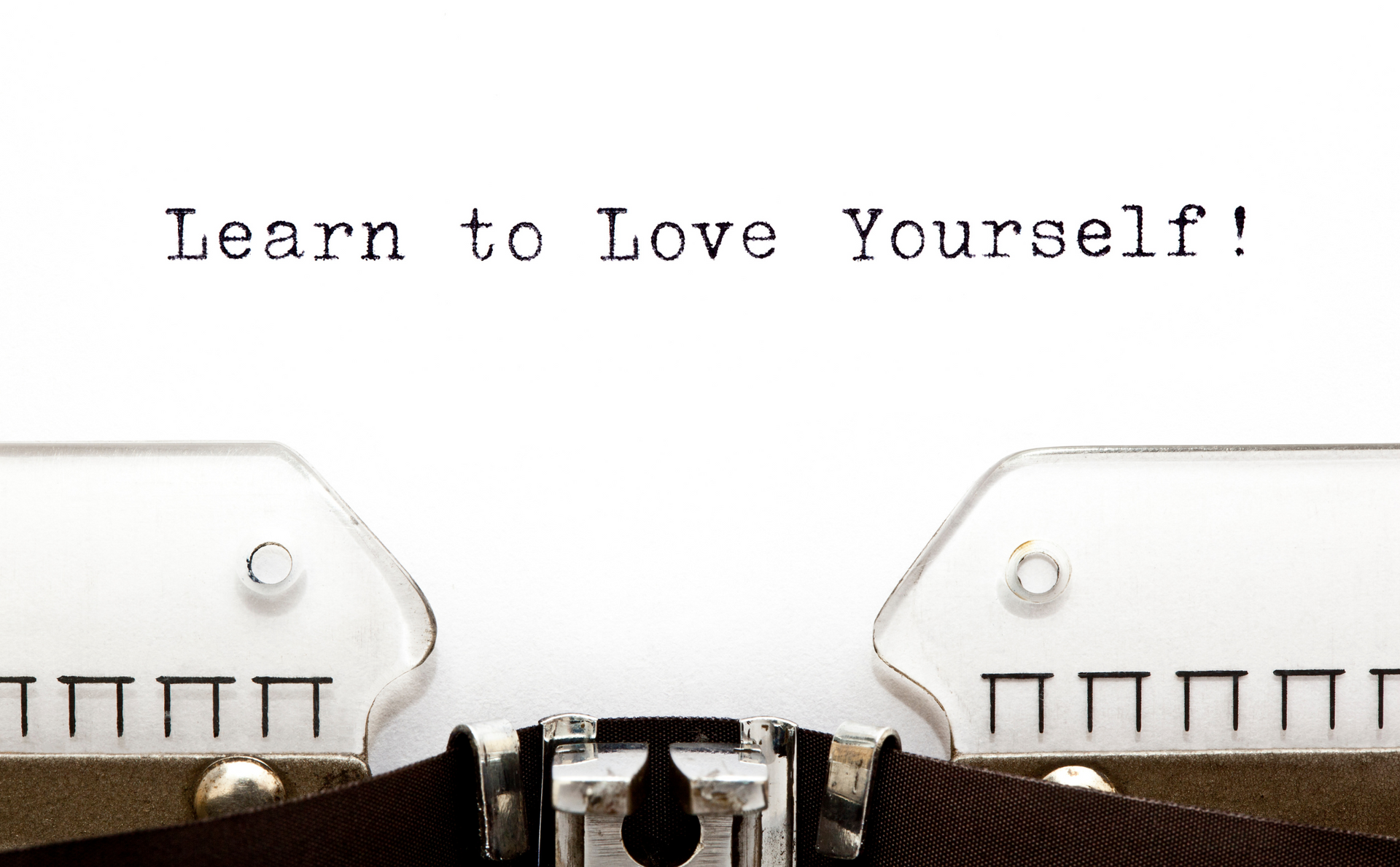 the words learn to love yourself are written on a typewriter .