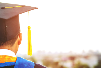 the back of a graduate wearing a graduation cap and gown .
