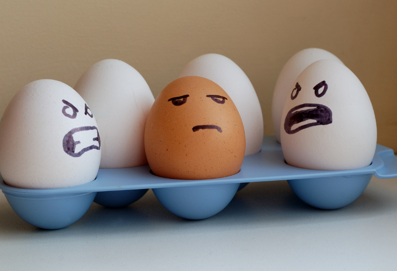 eggs with faces drawn on them are in a tray