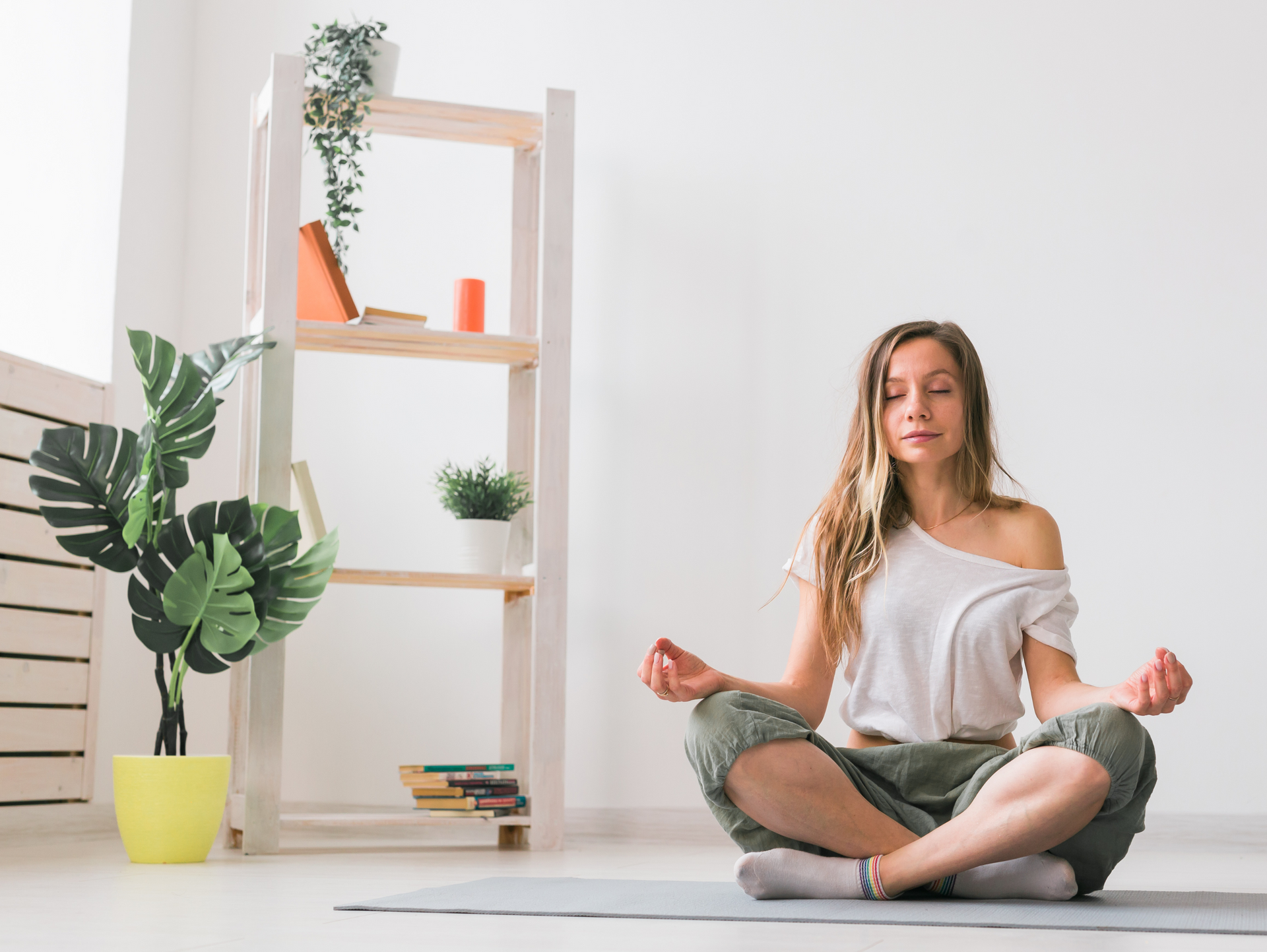 a woman is sitting on a yoga mat in a lotus position .