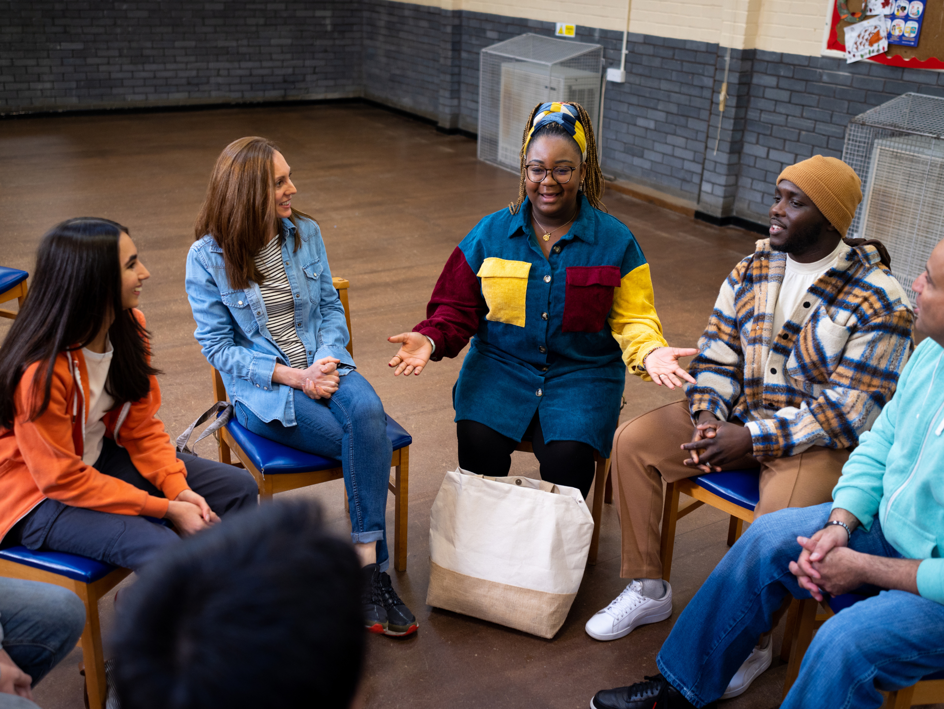 a group of people are sitting in a circle talking to each other .