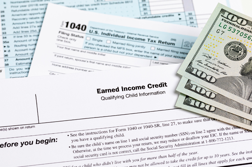 a 1040 tax form is sitting on top of a pile of money .