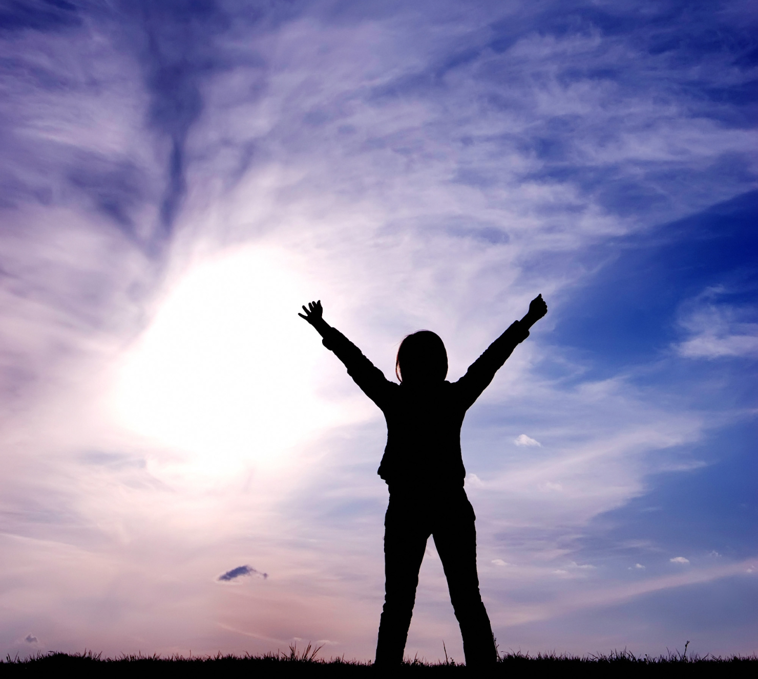 a silhouette of a person with their arms in the air